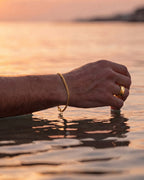 Gold Cuban tag bracelet and gold Ocean Ring worn at the sea at sunset
