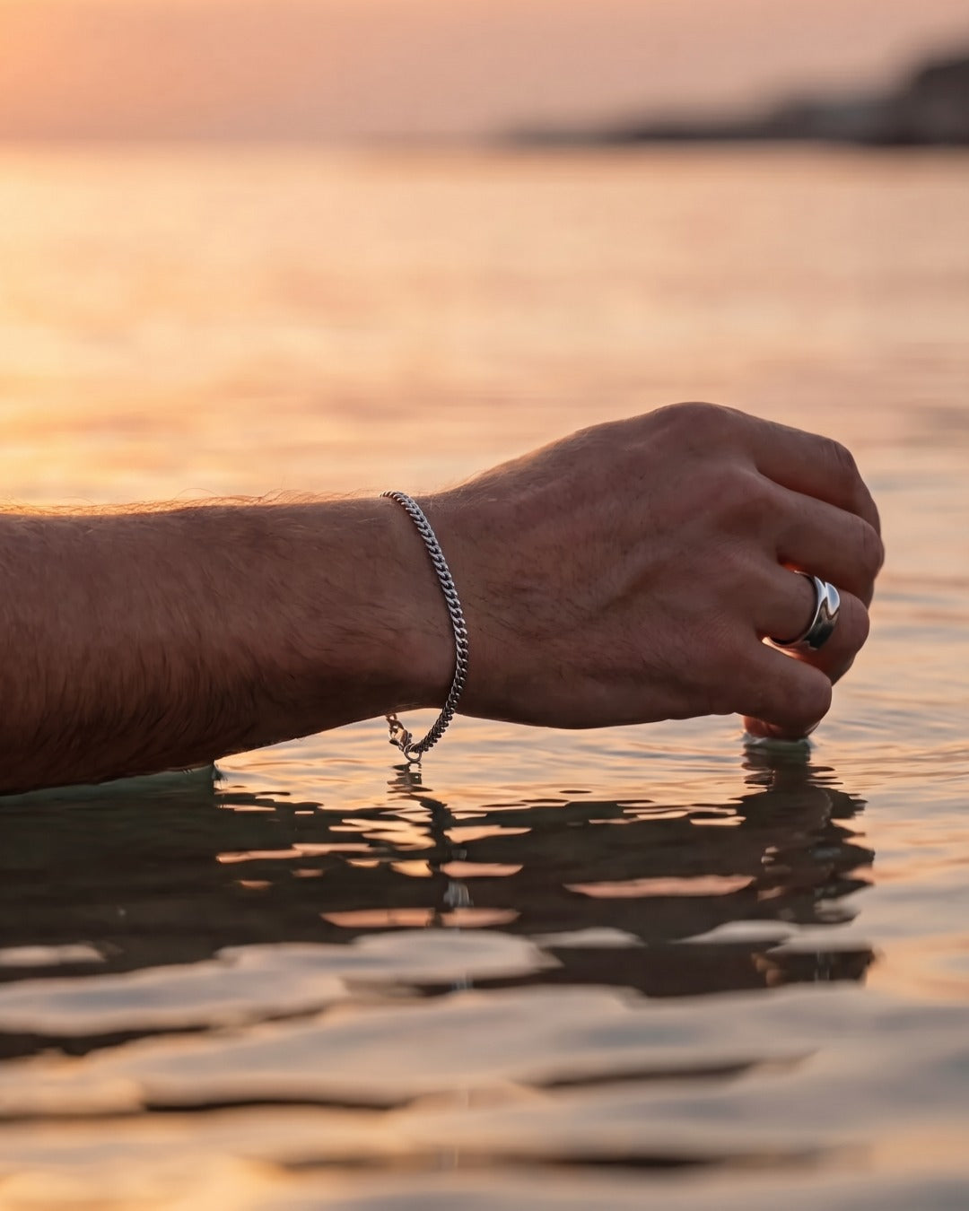 Silver Cuban tag bracelet and Ocean Ring worn at the sea at sunset