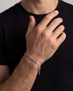 Fine silver Cuban chain bracelet on a man's wrist against a black t-shirt