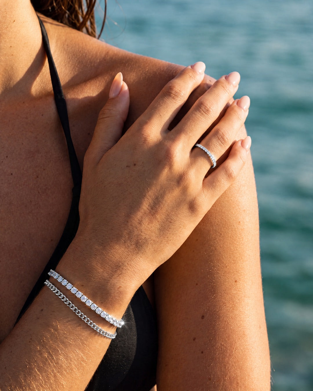 Silver bracelet stack with the Fine Tennis Bracelet, a fine chain bracelet and an eternity ring on the hand
