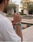 Polished silver-tone steel bracelet with emerald green stones, clean unisex design by Pureform