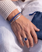 Polished silver-tone steel bracelet with sapphire blue stones, clean unisex design by Pureform