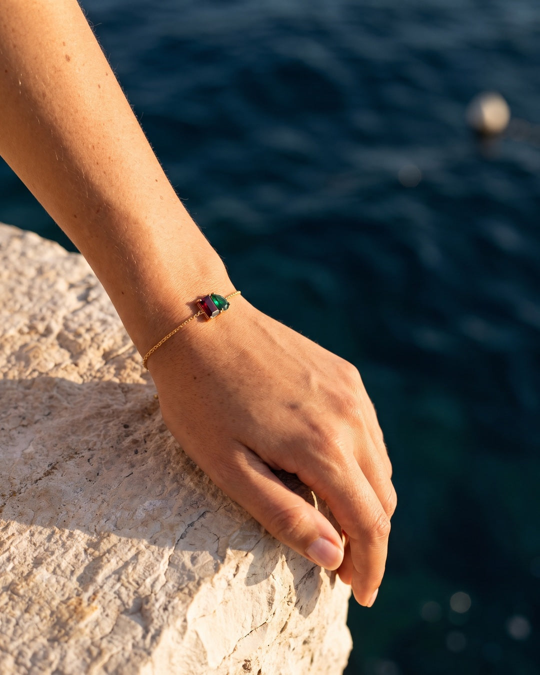 January birthstone bracelet in 14K gold, Siam red and emerald green stones, worn