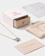 December birthstone necklace in 14K gold, aquamarine blue and light rose stones with Pureform gift packaging