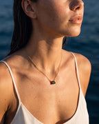 January birthstone necklace in 14K gold, Siam red and emerald green stones, worn