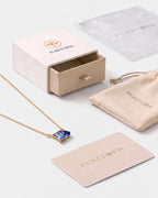 March birthstone necklace in 14K gold, light sapphire blue and sapphire blue stones with Pureform gift packaging