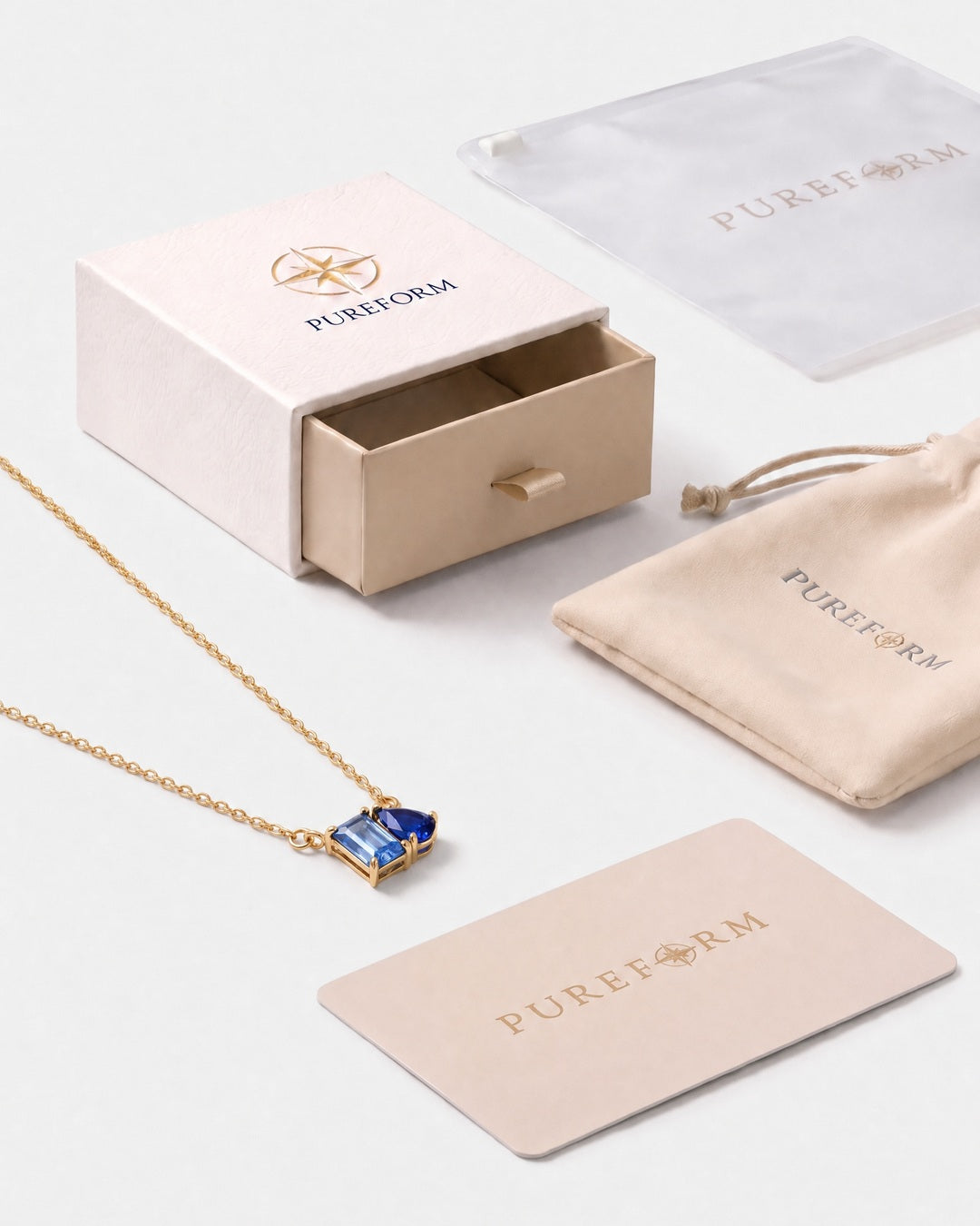 March birthstone necklace in 14K gold, light sapphire blue and sapphire blue stones with Pureform gift packaging