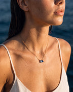 March birthstone necklace in 14K gold, light sapphire blue and sapphire blue stones, worn