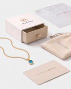 Lumière birthstone necklace in blue topaz gold with Pureform jewelry packaging